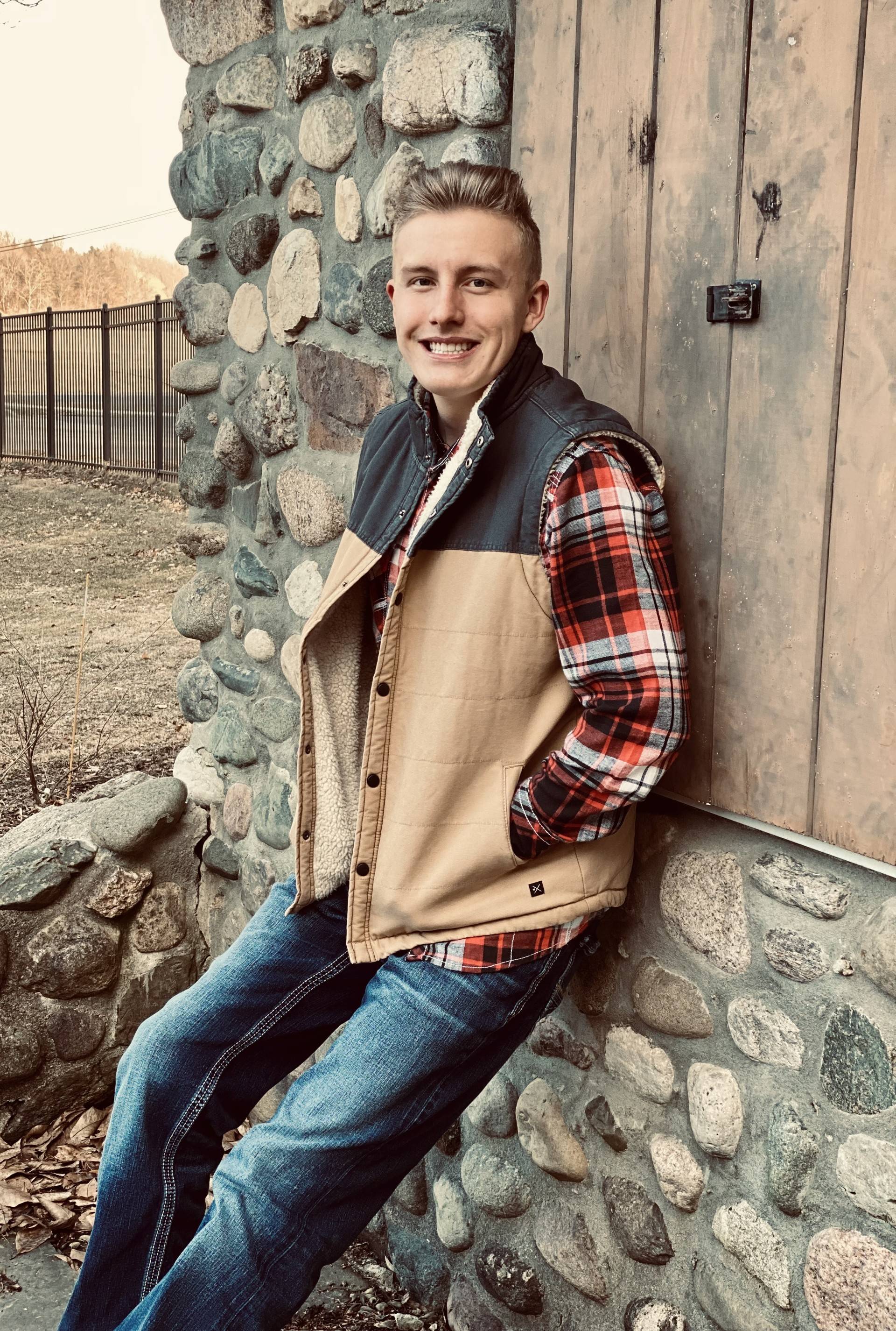Wyatt Purucker outside, leaning against a rustic building
